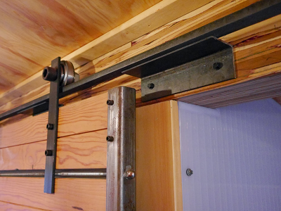 FARM HOUSE: The interior feature we like best is a full sliding wall which creates privacy when using the bathroom, shower or sleeping area. Here's a close-up of the hardware, sliding mechanism and wall-door. (Yestermorrow, Relaxshacks)